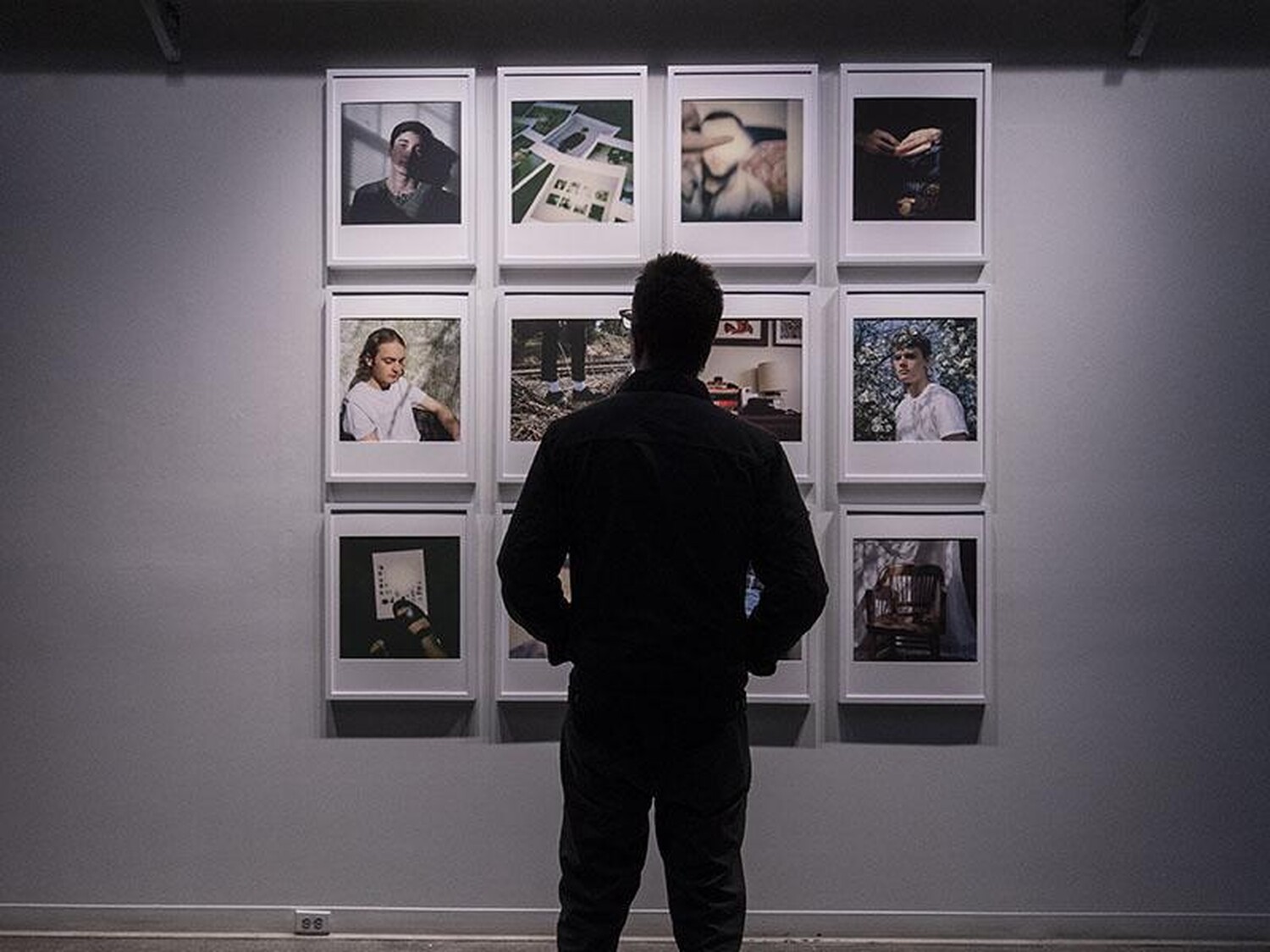 A person looking at a Gallery Wall of art