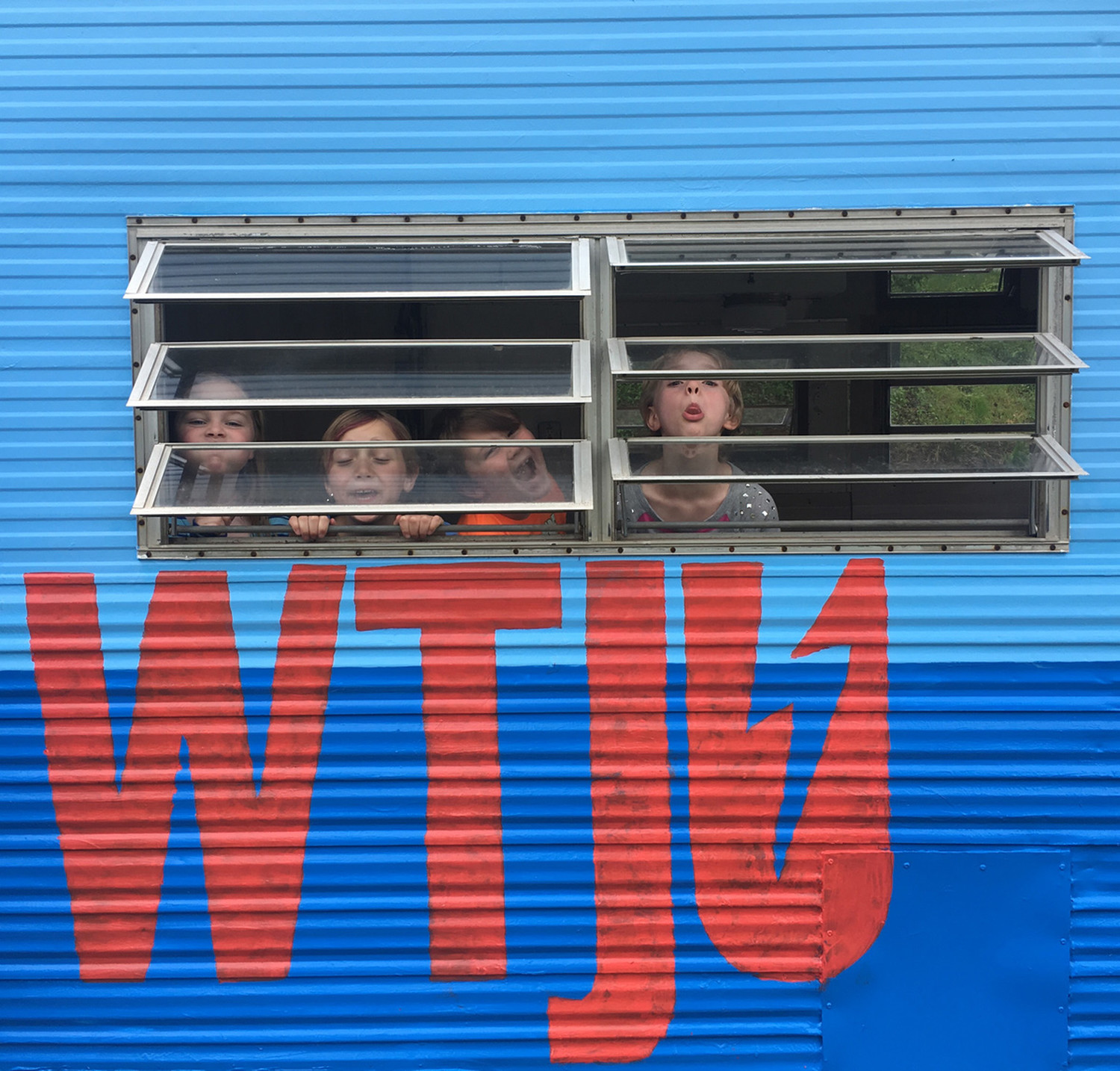 Kids peeking through windows of WTJU To-Go trailer