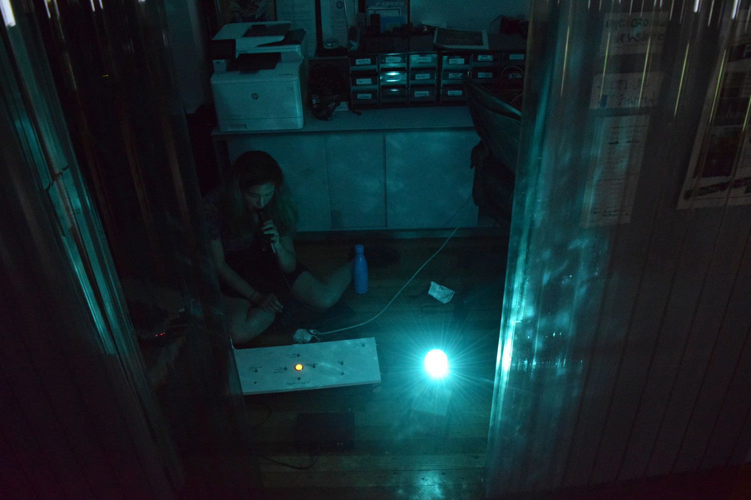 Girl in dark room working with technology 