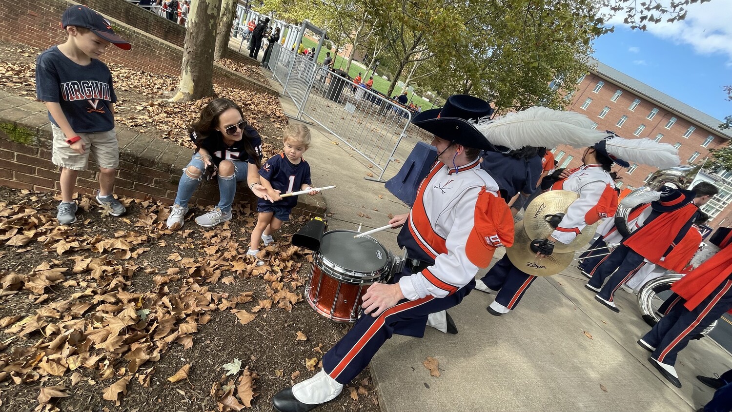 UVA Drumline Center Snare gives an impromptu drum lesson to a young football fan on October 23, 2021.