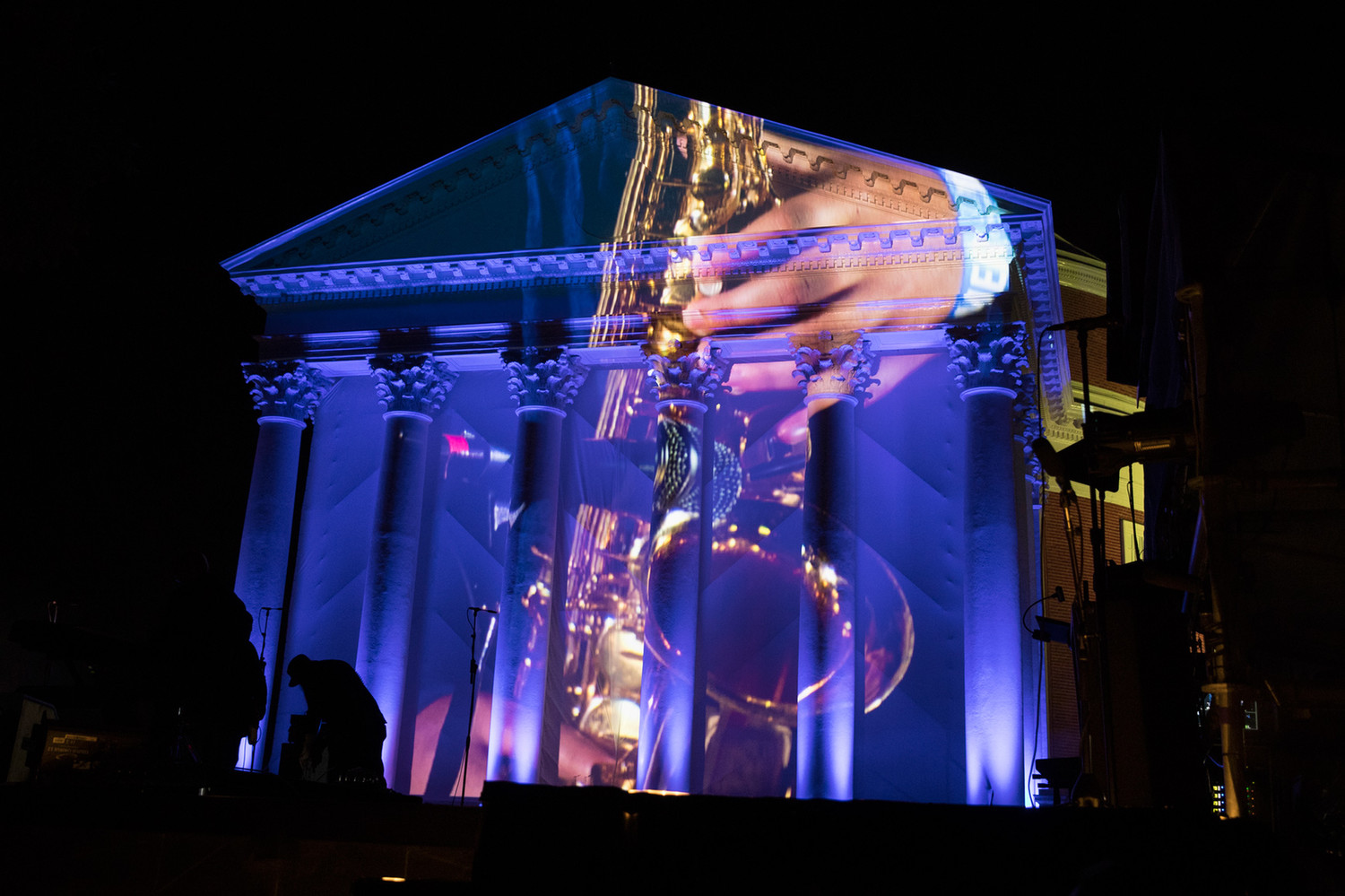 A saxophonist from UVA's Jazz Ensemble projected on the Rotunda