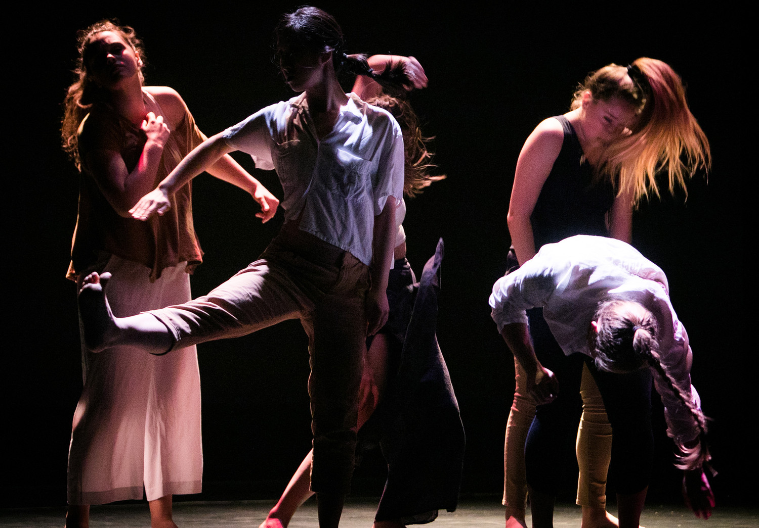 Five dancers onstage in dim lighting