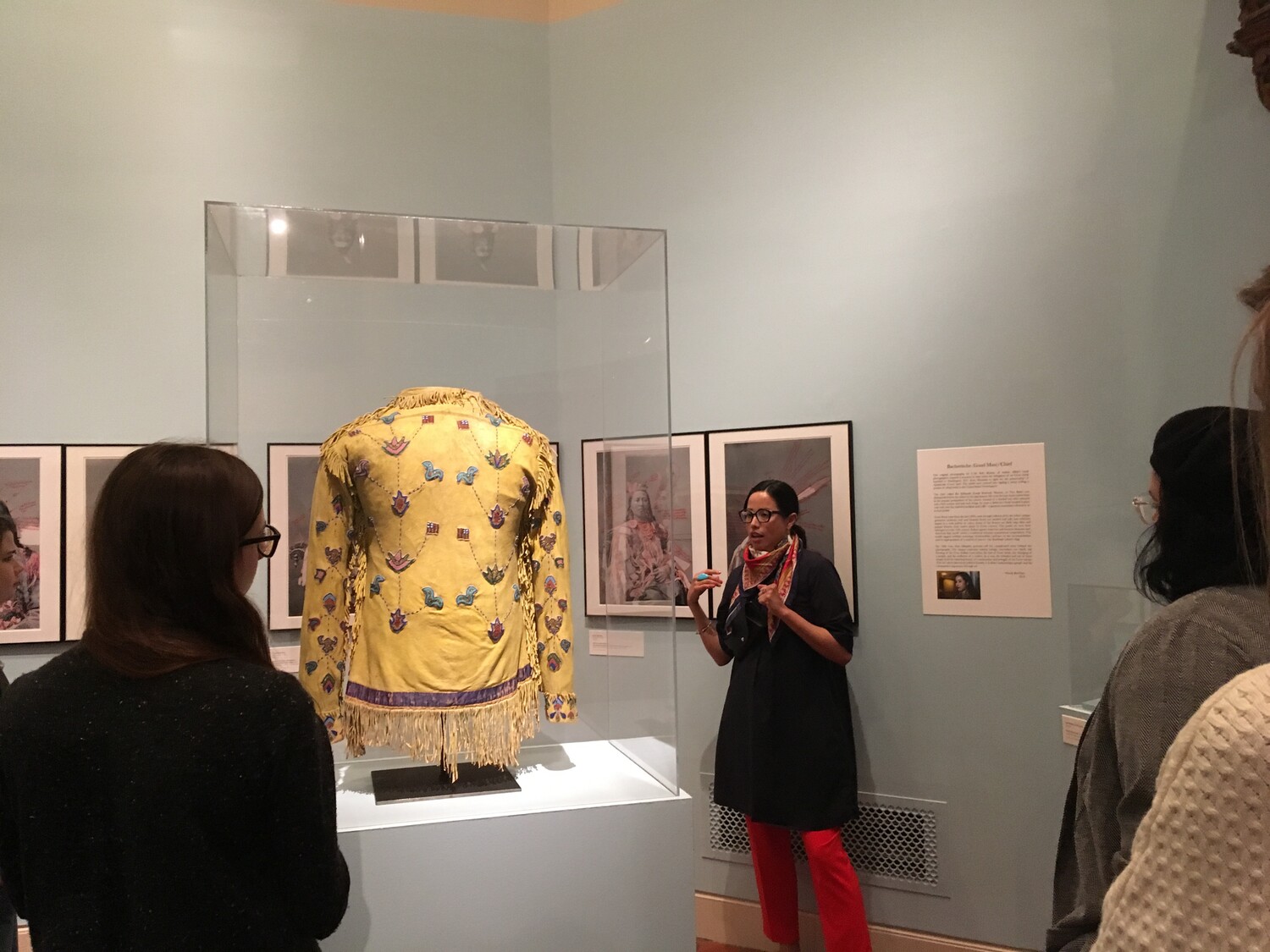 Wendy Red Star (Apsáalooke) connecting her print series 1880 Crow Peace Delegation (on wall) to a beaded Apsáalooke jacket during a gallery talk in The Fralin’s Reflections: Native Art Across Generations. Fall 2019. Photo: Adriana Greci Green