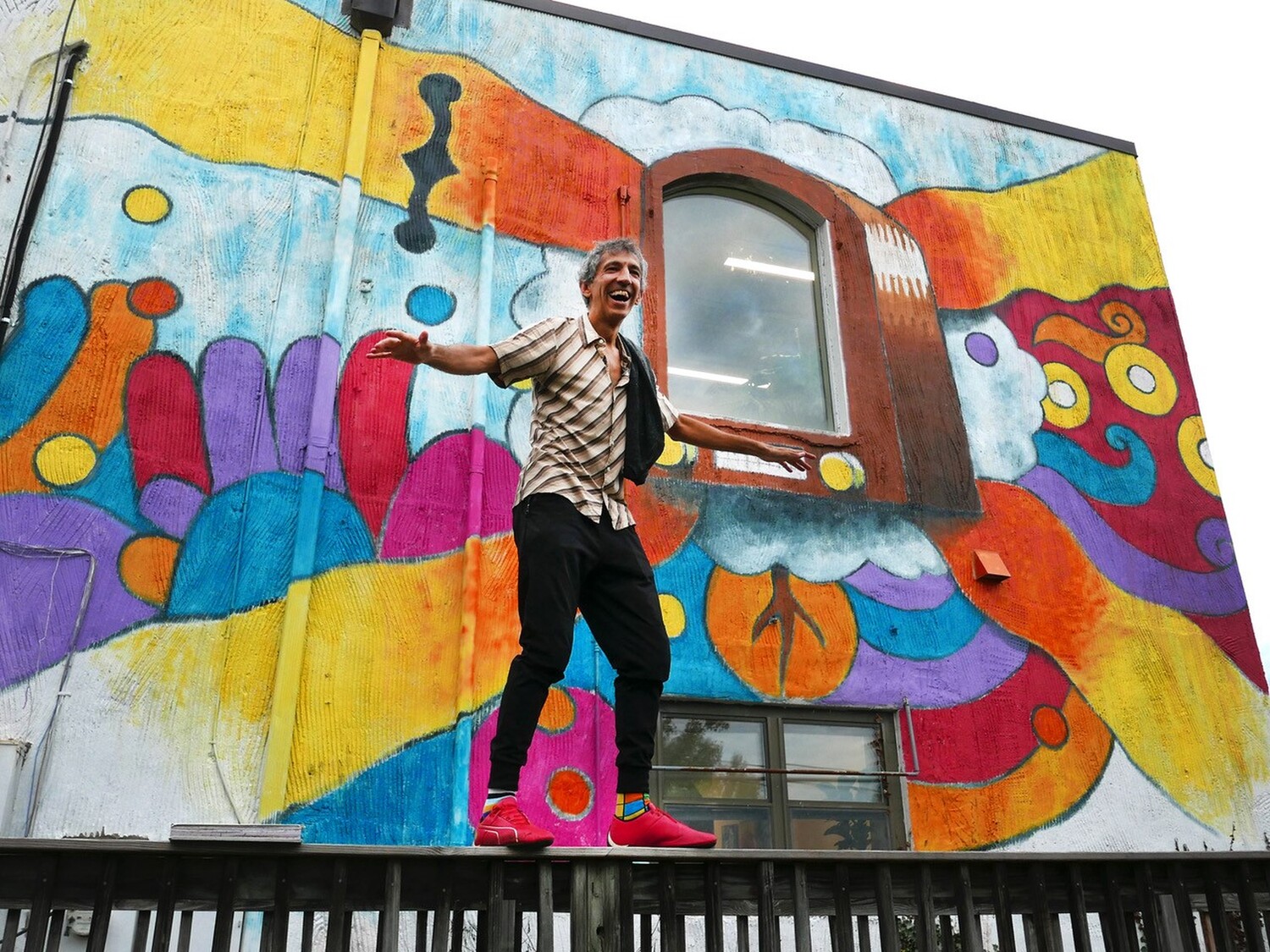 Artist Chicho Lorenzo in front of his newest mural at WTJU 91.1FM. Image by Dan Grogan